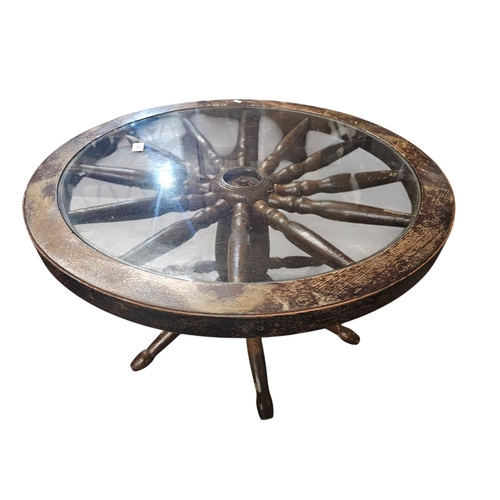 744 - Solid wagon wheel base glass topped table