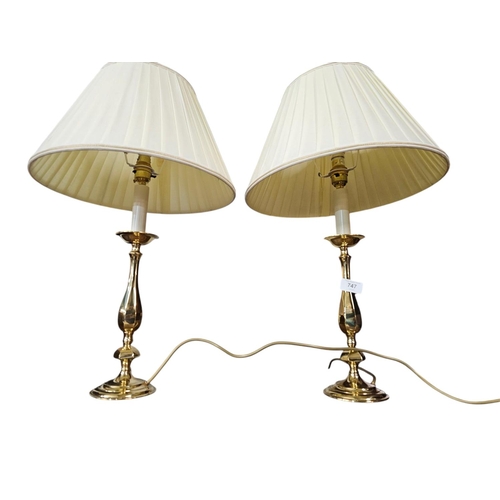 747 - Pair of brass candle stick style table lamps with cream shades