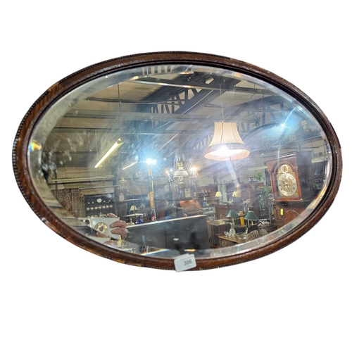 306 - Large Victorian wooden framed oval mirror with carved detail