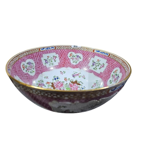 400 - A large Chinese famillie rose style punch bowl with amoreal design and panel of flowers against a pi... 