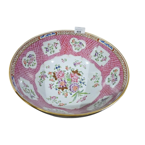 400 - A large Chinese famillie rose style punch bowl with amoreal design and panel of flowers against a pi... 