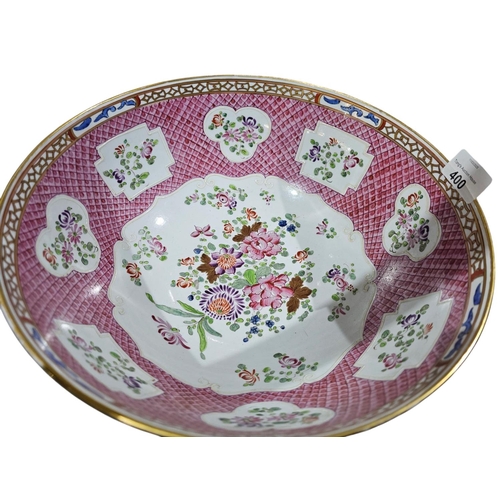 400 - A large Chinese famillie rose style punch bowl with amoreal design and panel of flowers against a pi... 