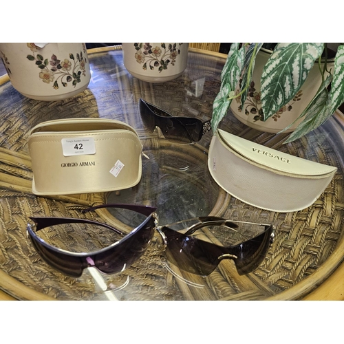 42 - Two pairs of cased sunglasses one by Gorgio Armani and one pair Versace