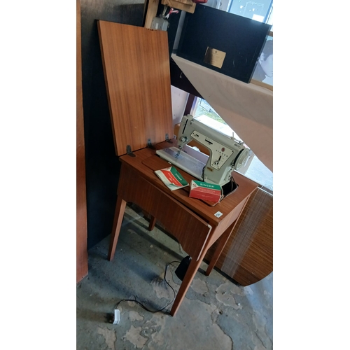 516 - vintage Singer sewing machine housed in a mid-century modern wooden cabinet.  Also mid-century table