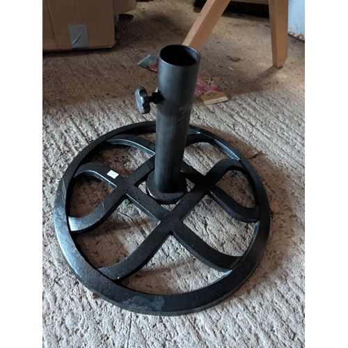 60A - cast iron round patio umbrella base with a black finish.