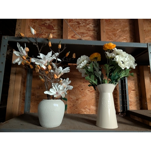 60B - faux magnolia branch arrangements in textured ceramic vase and another in metal jug.