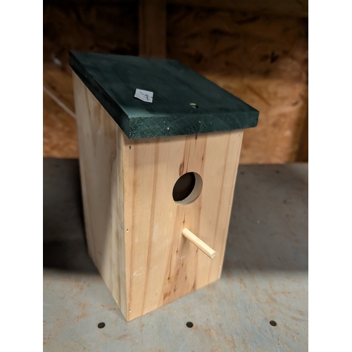 60H - traditional wooden birdhouse with a green roof.