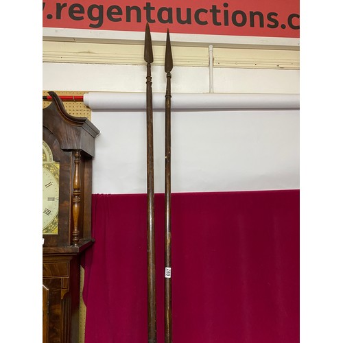 671 - Pair of replica pikes on wooden round shafts measuring 265 cms long