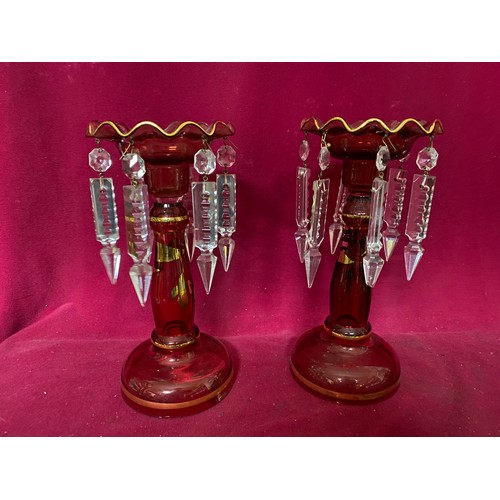 931 - Pair of cranberry candlesticks with clear glass drops. 23cms