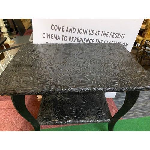 698 - Highly decorative dark wood table. Carved flower top and matching lower shelf measuring 75 x 50 cms