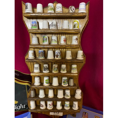 513 - Collection of 44 porcelain and metal thimbles on display holder accompanied with 2 books