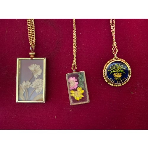 119 - 3 Pendant necklaces on gold coloured chains, 2 with flower inset and one with pound coin in colour i... 