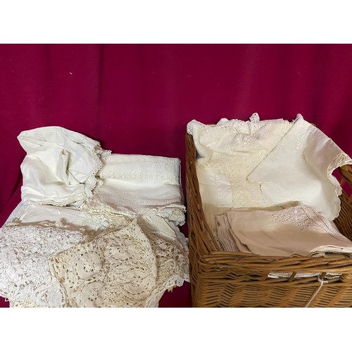 580 - Antique linen, silk and lace tablecloths, napkins, pillowcases and runners in wicker basket.