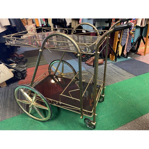 314 - Vintage drinks trolley in gold metal and smokey glass shelves