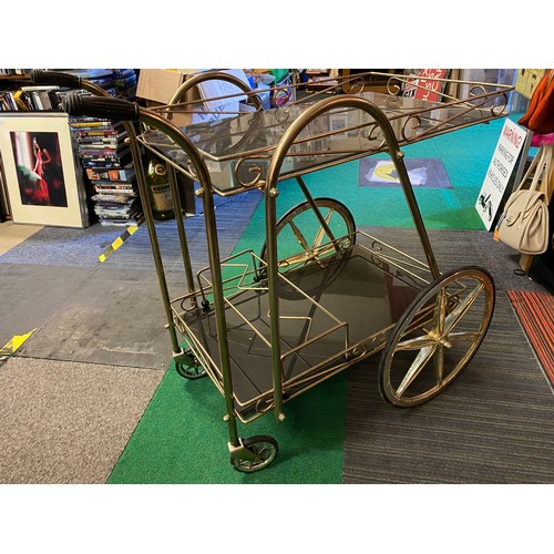 314 - Vintage drinks trolley in gold metal and smokey glass shelves