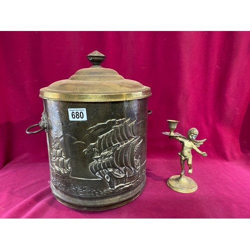 680 - Brass embossed coal bucket standing 36 cms tall and cherub candle holder standing 20 cms tall