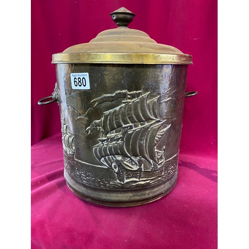 680 - Brass embossed coal bucket standing 36 cms tall and cherub candle holder standing 20 cms tall