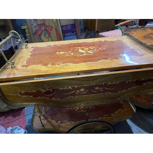 150 - Drinks trolley with decorative inlay top and under shelf, brass trim and wheels. Top shelf extends a... 