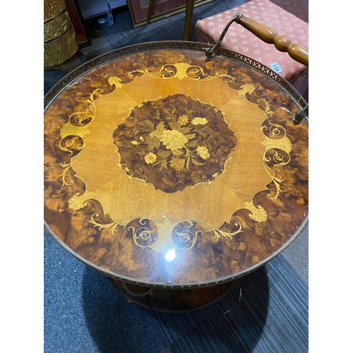 151 - Round drinks table with decorative inlay top and lower shelf, bottle holder and brass trim. 55x62cms