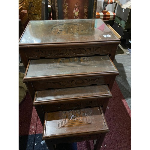 153 - Nest of 4 decorative oriental style dark wood tables with glass tops, largest measures 66x30x35cms. ... 