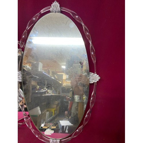 474 - 2 x frameless mirrors with decorative trim, a 70 x 43 cms oval mirror and a 53 cms round mirror