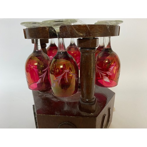 213 - Musical glass holder in wood with 6 cranberry style etched glasses. Will hold bottle in centre, work... 