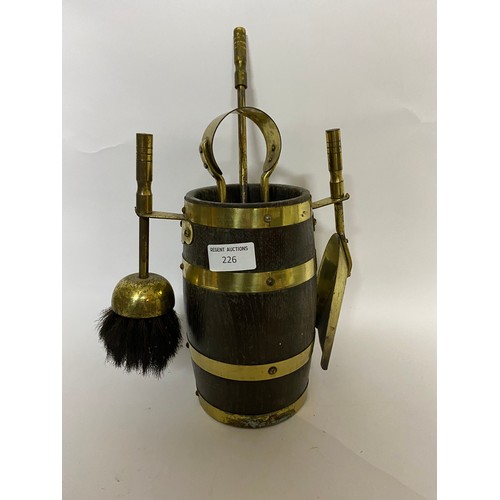 226 - Companion set containing brush, poker, tongs and shovel in wooden barrel