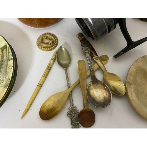 379 - Box of curios including spoons, fishing reel, plates, magic cube etc