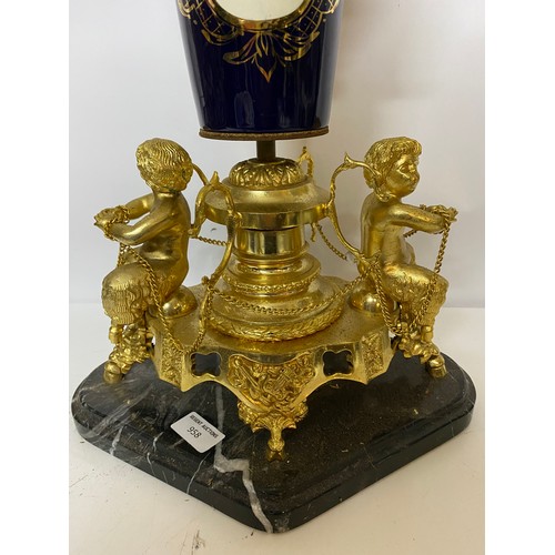 958 - Ornate centrepiece with marble base and gold tone cherubs and cobalt blue urn measuring 58 cms tall