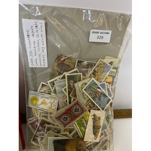 329 - Selection of stamps, cigarette cards, first day covers and postcards.