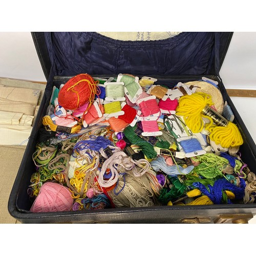 665 - Vintage black case filled with selection of embroidery items including silks, rings, patterns and li... 