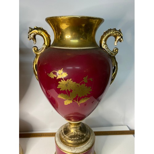 172 - Pair of large urns on pedestal bases in red and gold, some wear on gilt and damage to base, measurin... 