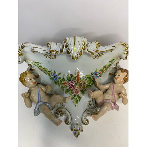 203 - Pair of porcelain cherub wall sconces measuring 28 cms wide x 17 cms deep