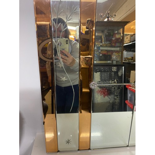 305 - A vintage art deco and peach coloured frameless mirror with bevelled panels measuring 91 cms square,... 