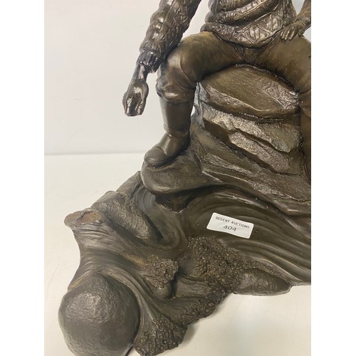 404 - Metal figurine depicting man and boy, some damage to mans hand measuring 29 cms tall