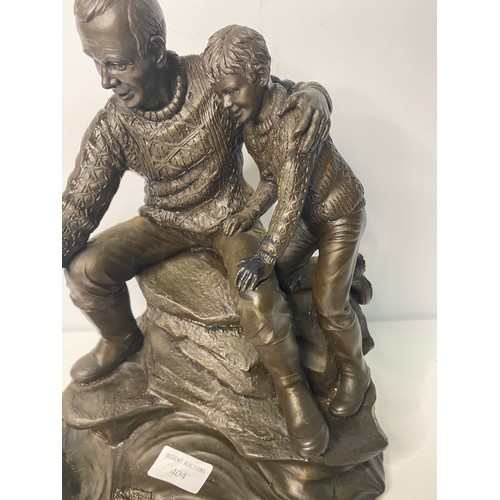 404 - Metal figurine depicting man and boy, some damage to mans hand measuring 29 cms tall