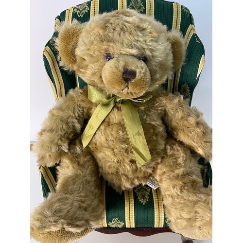 709 - Harrods bear sat on a wingback upholstered armchair