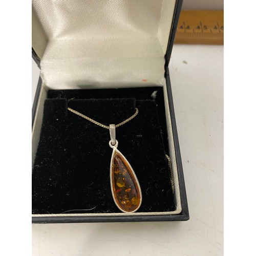 529 - Amber pendant set in silver and silver chain.