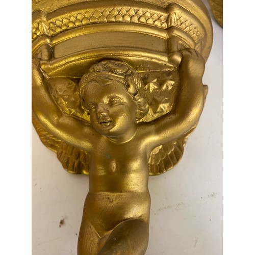 818 - Pair of gold cherub sconces measuring 31 cms tall