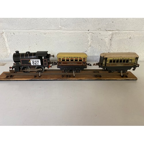 827 - Hornby display on wooden plinth. Type 40 clockwork locomotive to front and 2 carriages behind, Marjo... 