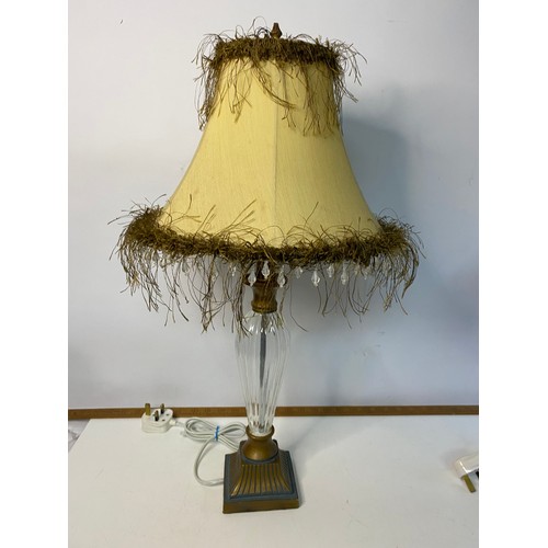 775 - Pair of glass column table lamps with fringed shades, in working order, measuring 57 cm tall.