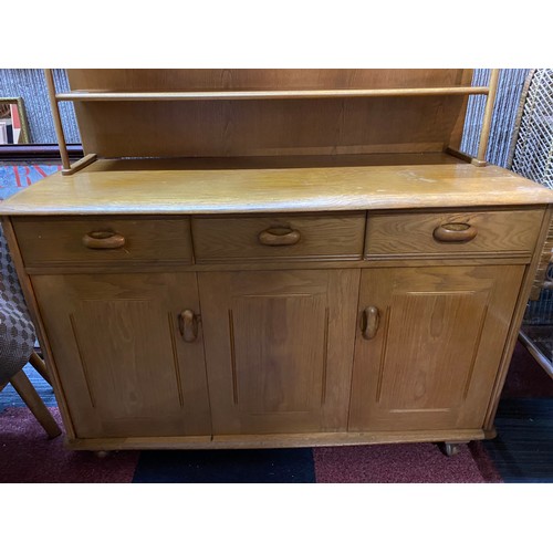 955 - Ercol style light oak sideboard with concertina opening door, 3 drawers and display shelving to top.