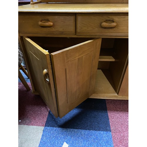 955 - Ercol style light oak sideboard with concertina opening door, 3 drawers and display shelving to top.