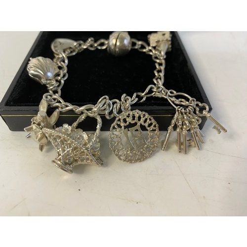 120 - Silver charm bracelet with 7 charms.