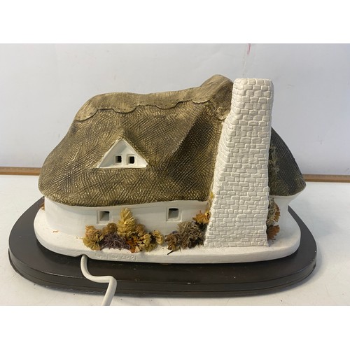 292 - Granville Paul light up ceramic cottage on wood plinth. Signed and dated 2001 and measures 30x23cms.