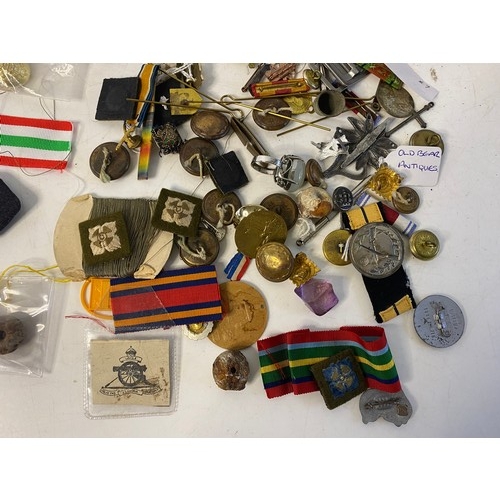 57 - Selection of Militaria including badges, patches, buttons, pins and ribbons.