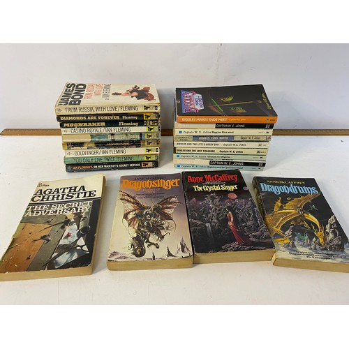 696 - Selection of vintage paperback books including 9 James Bond, Biggles and Agatha Christie