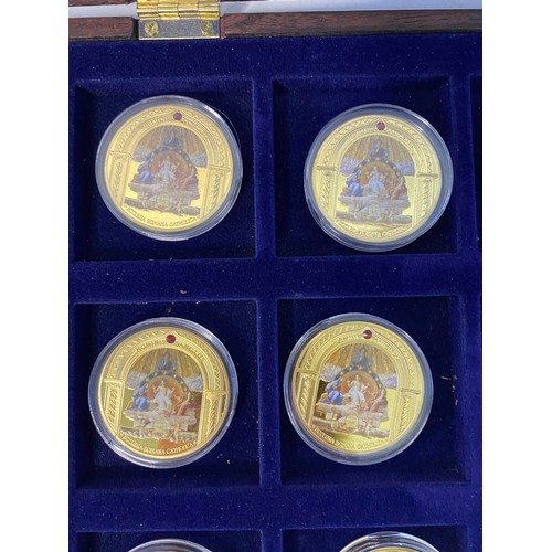 1007 - Selection of 10 Religous gold tone commemorative coins with colour pictures in display case.