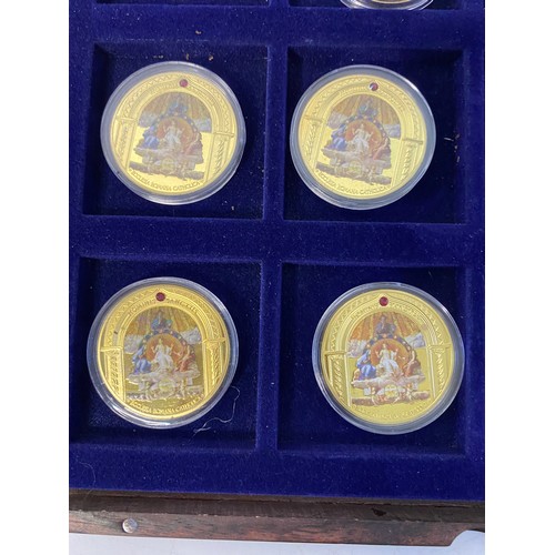 1007 - Selection of 10 Religous gold tone commemorative coins with colour pictures in display case.