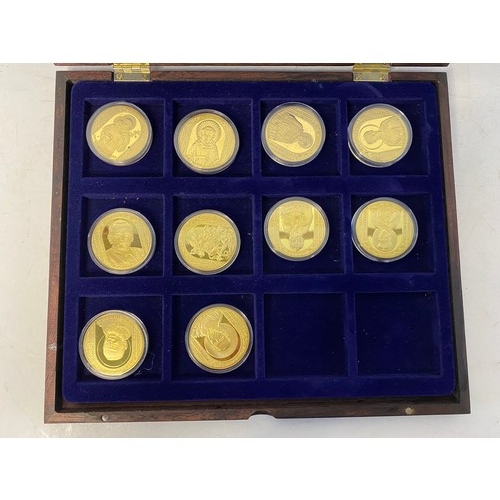 1007 - Selection of 10 Religous gold tone commemorative coins with colour pictures in display case.